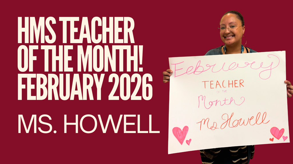 Ms. Howell holding a Teacher of the Month poster.