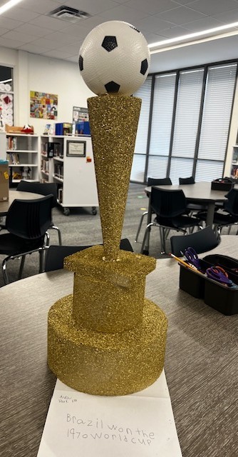 trophy made of styrofoam pieces painted gold and a plastic soccer ball on the top