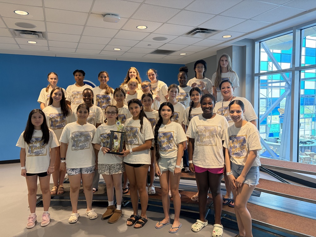 Choir students standing with a trophy.
