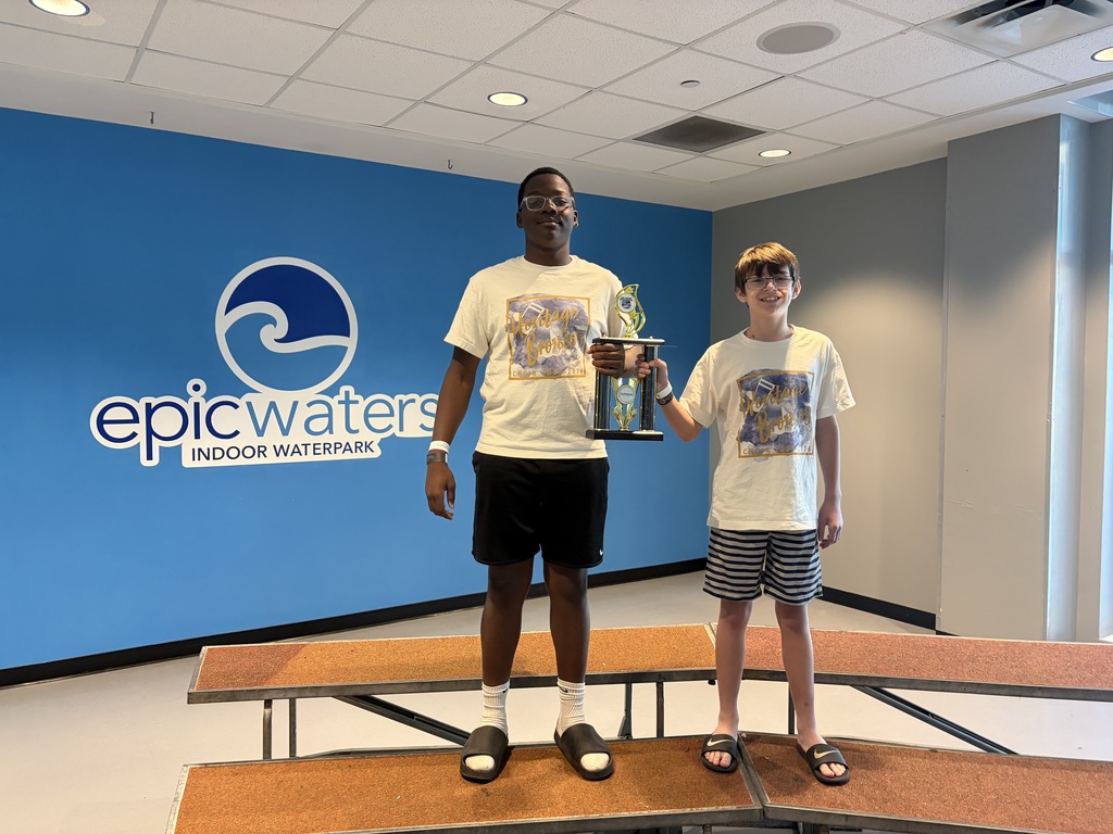 Choir students standing with a trophy.