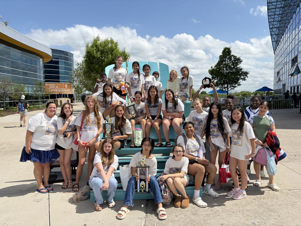 Choir students standing with a trophy.