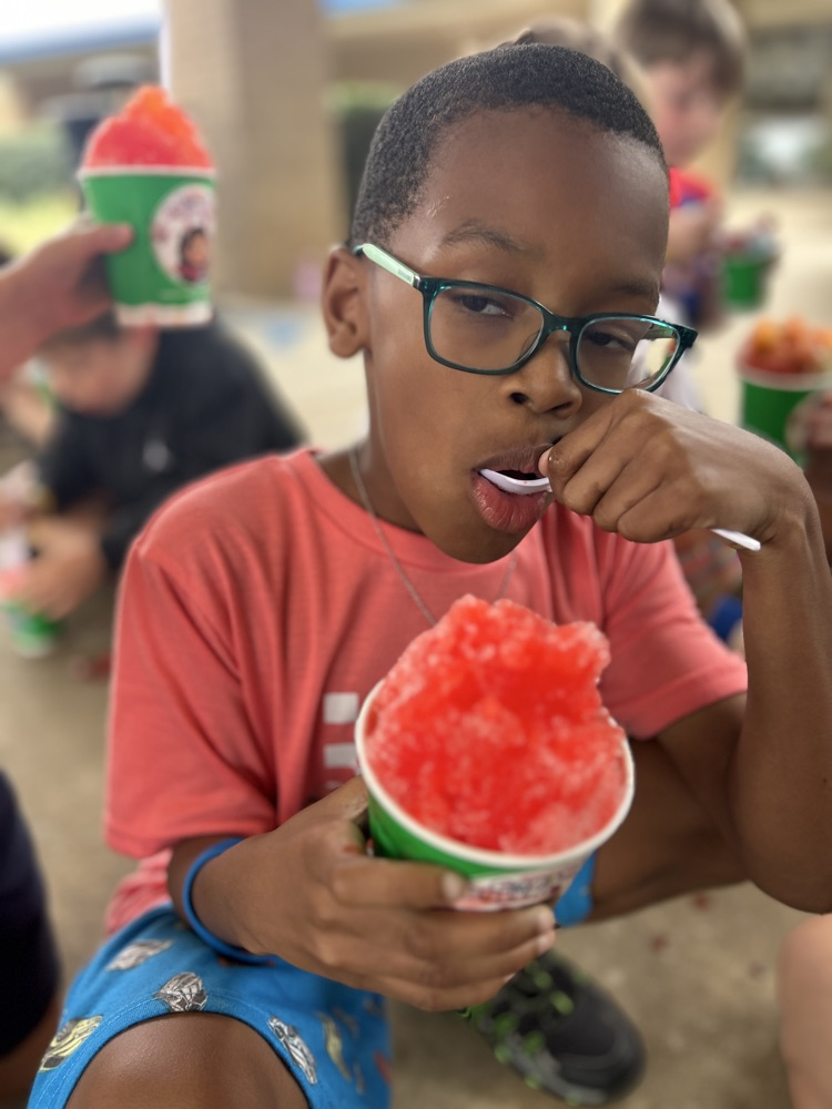male child eating snow cone