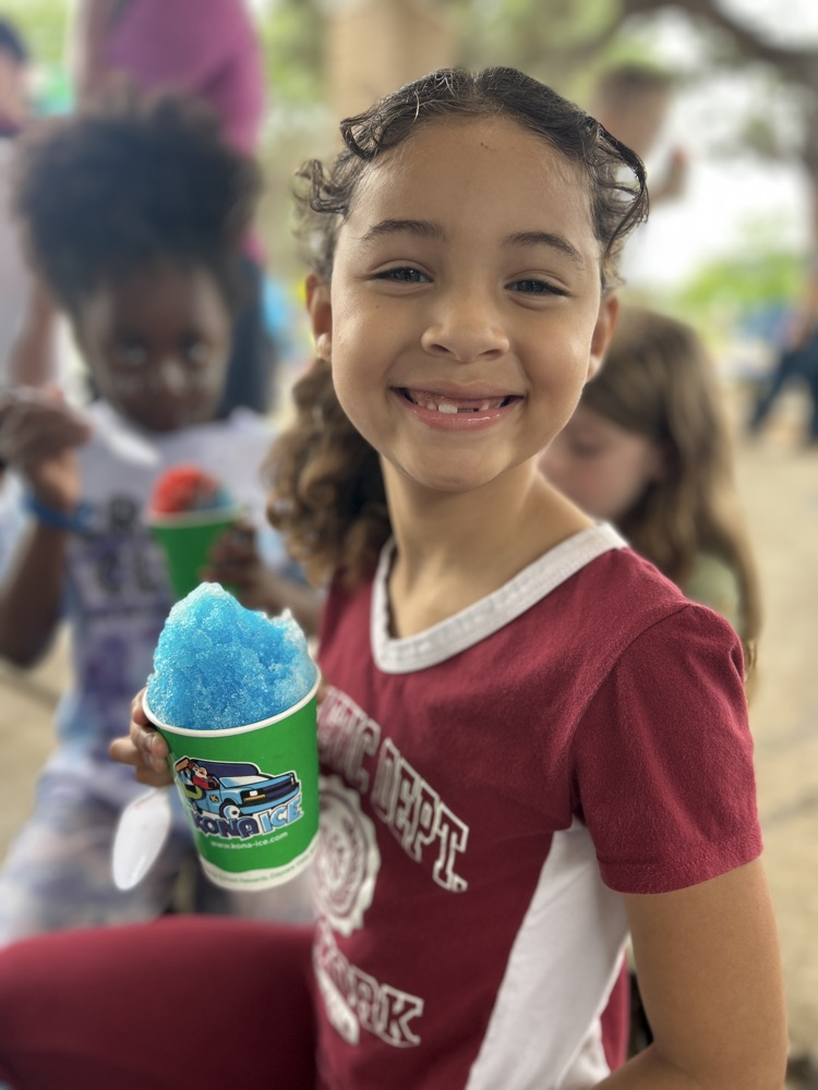 female child eating snow cone