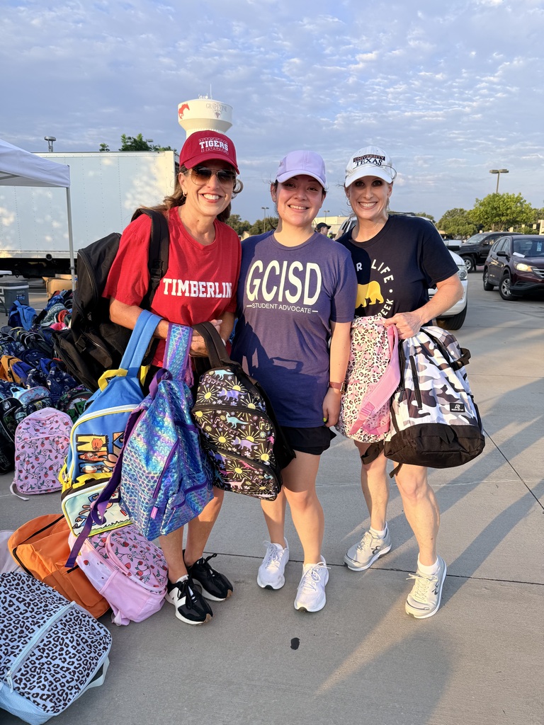 Three educators holding backpacks