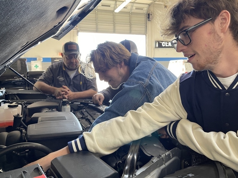 students working on a car