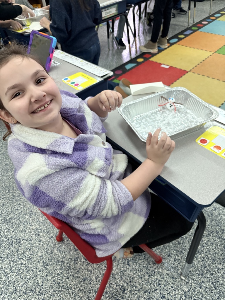 Students creating snowmen using indoor snow