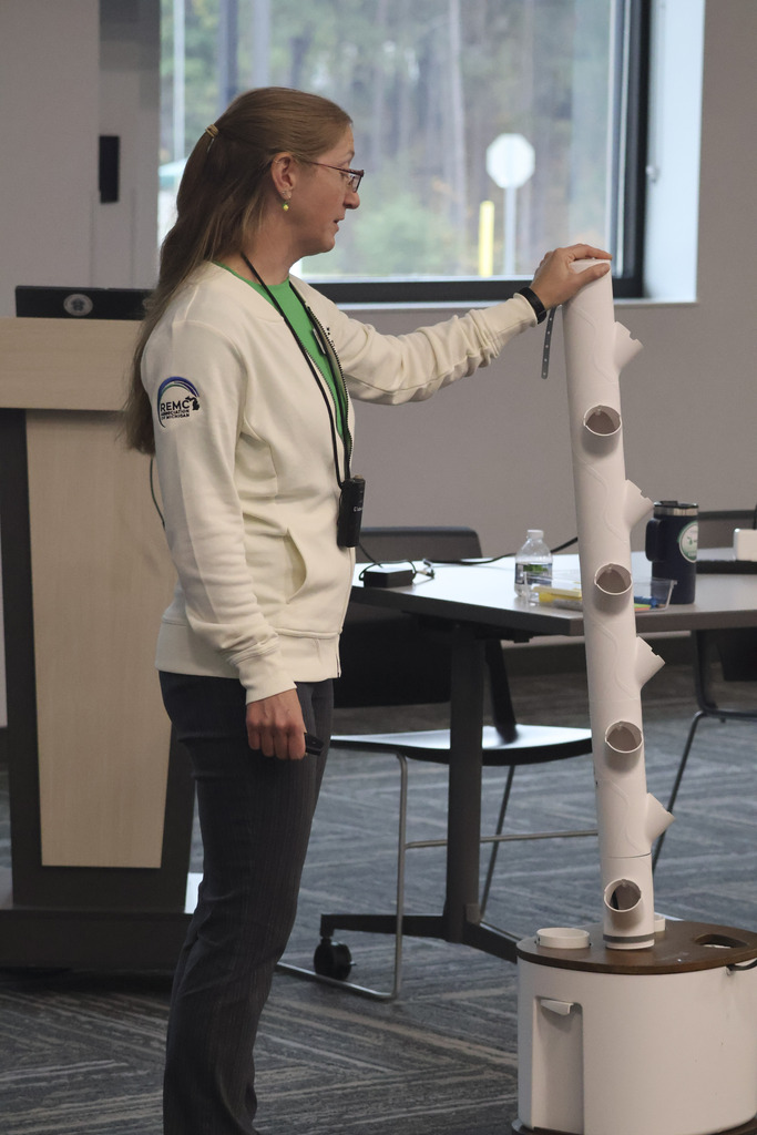 The presenter shows off the tower hydroponics setup that teachers received.