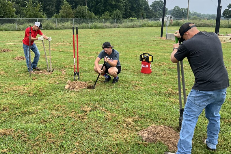 Student volunteers from GHS FFA helping to install the fence for the Outdoor Classroom over the summer