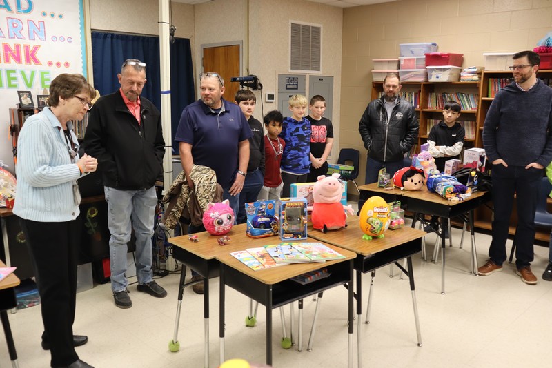 Mrs. Riggs and her students present a toy drive the class ran to the school board in 2025
