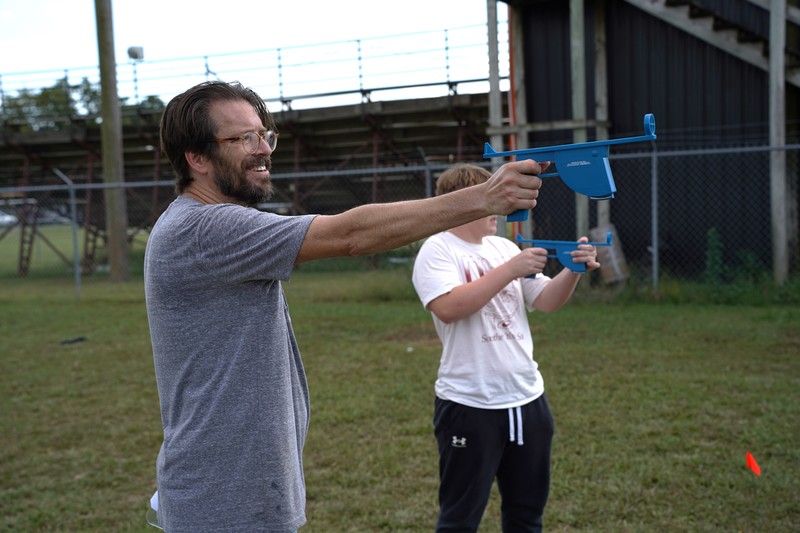 Mr. Leach demonstrating how to measure the altitude of water bottle rockets to find the winning experiment