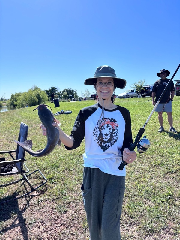 Shirley Reynolds holding the first fish she has ever caught in her life the week before retirement