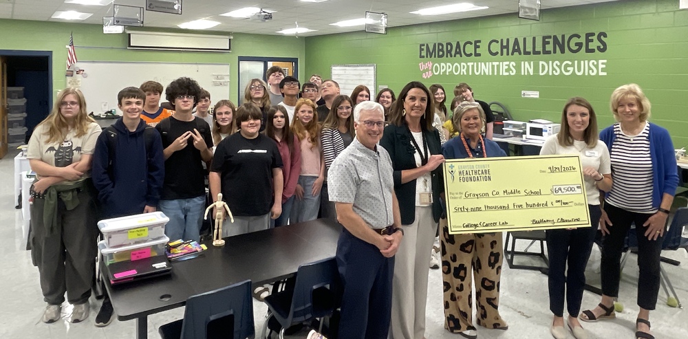 students and healthcare professionals hold a ceremonial check in the GCMS career lab