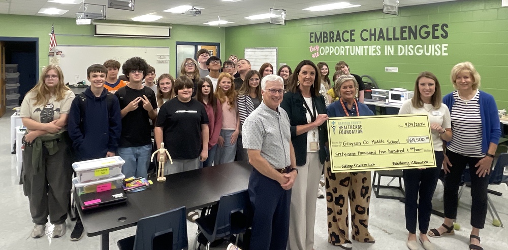 students and healthcare professionals hold a ceremonial check in the GCMS career lab