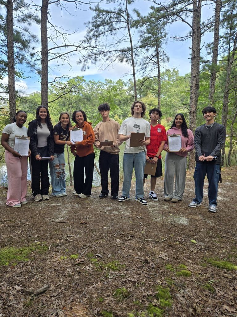 anatomy students stand together at the AHS pond with clipboards