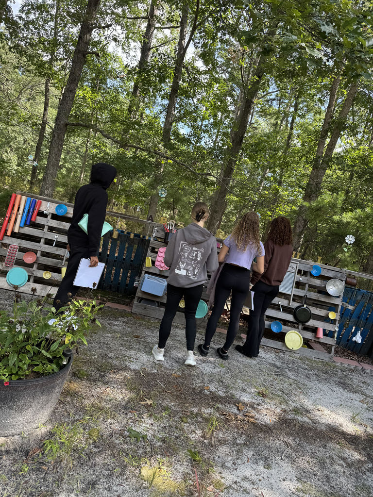 students stand in front of pond interactive exhibits