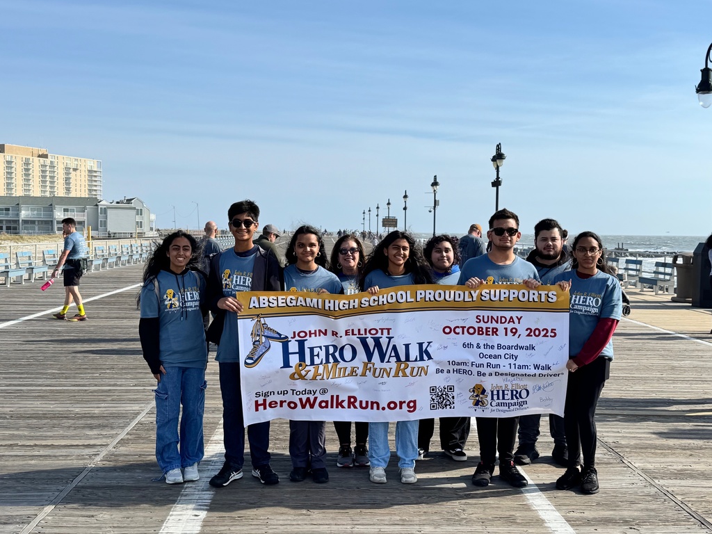 fbla group stands together on boardwalk holding sign