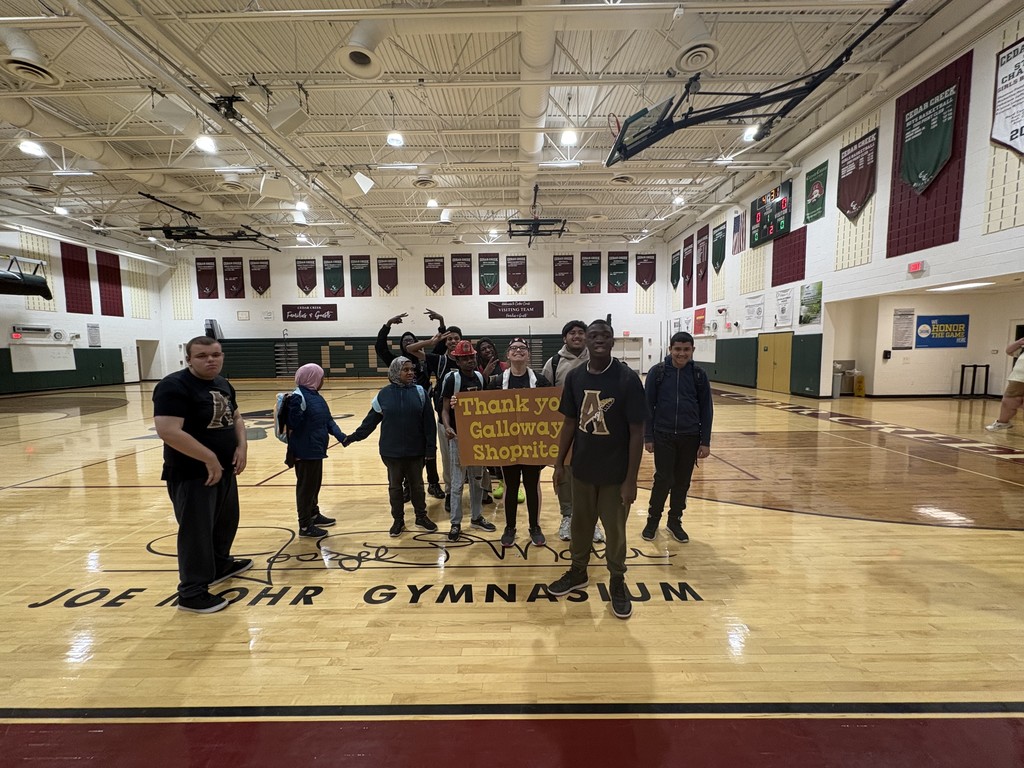 kickball team standing with a sign that says thank you shoprite