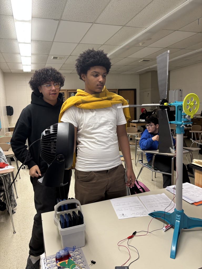 Student holding a fan testing a a wind turbine.