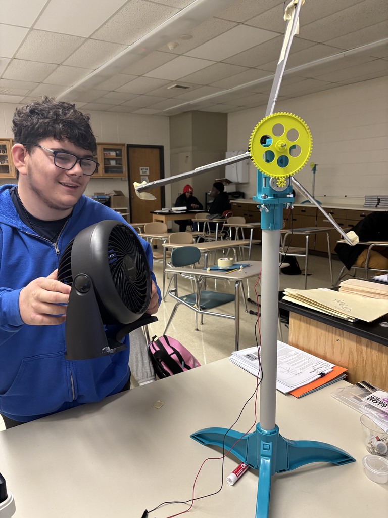 Student holding a fan testing a a wind turbine.
