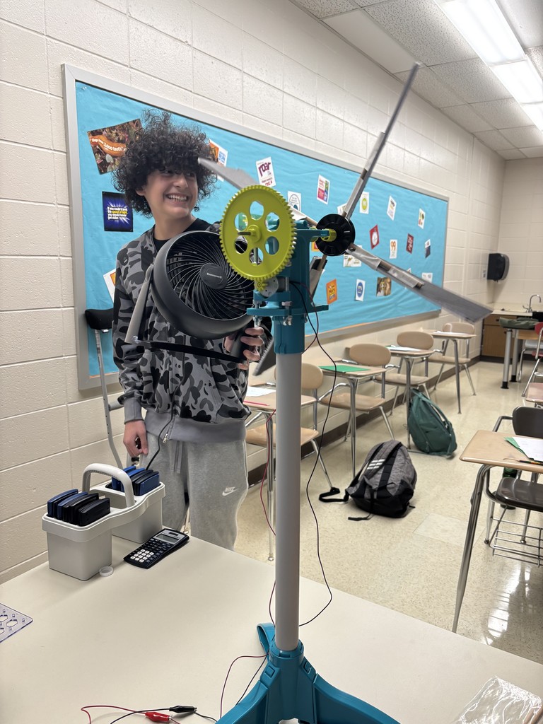 Student holding a fan testing a a wind turbine.