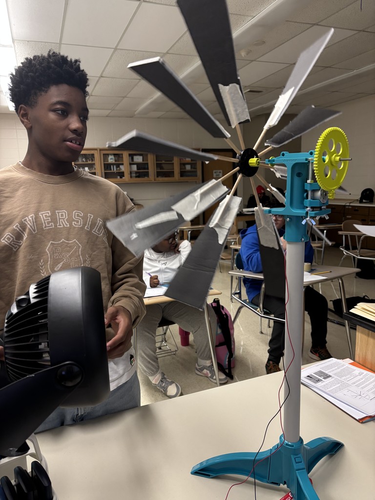 Student holding a fan testing a a wind turbine.