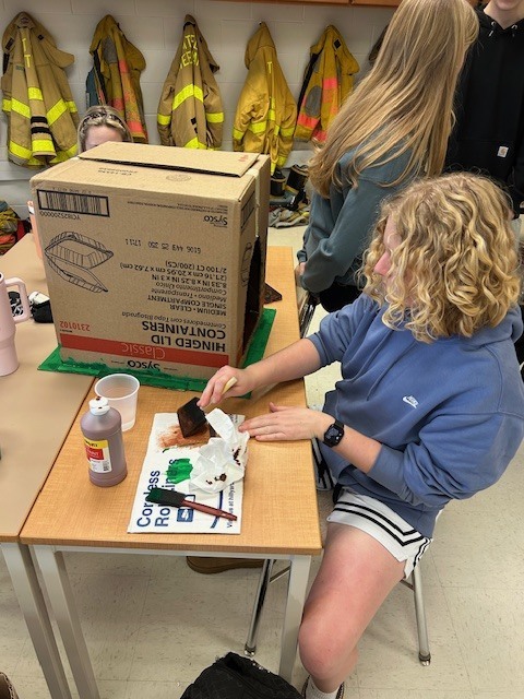 The firefighting students are building structures to predict fire behavior. 