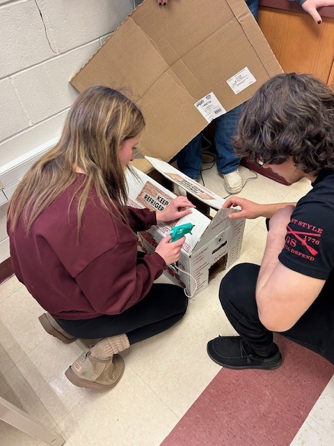 The firefighting students are building structures to predict fire behavior. 