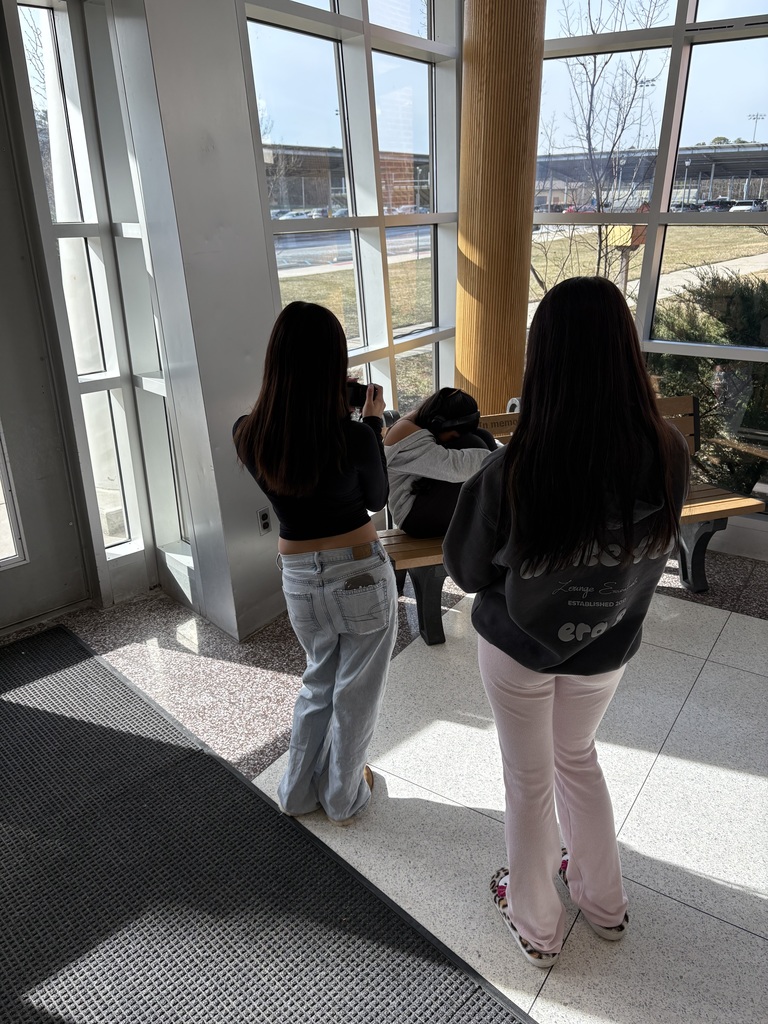 Student posing while other students take a portrait