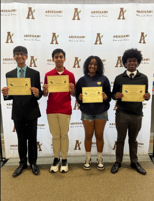 Four individuals, dressed in formal attire, stand behind a backdrop with large letter A's. They each hold a yellow certificate.