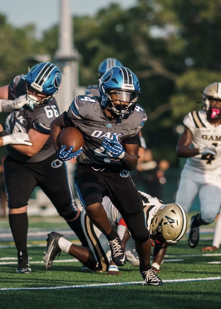 A football game with players in numbered jerseys. A player in gray with "DAV" runs with the ball.