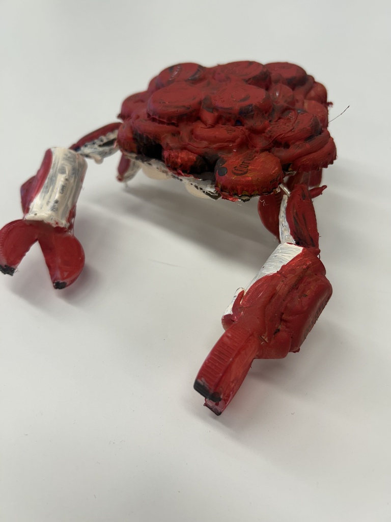 A red, white, and black art piece resembling a crab on a white background.