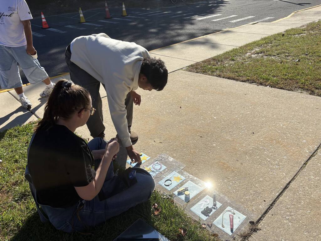 Student placing objects on cyanotype paper