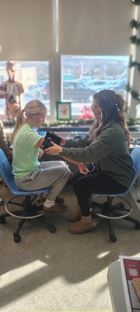 School Counselor Mrs. VanLeeuwen gets a hands on lesson in taking blood pressure from one of our New Visions Health Careers Exploration students. 