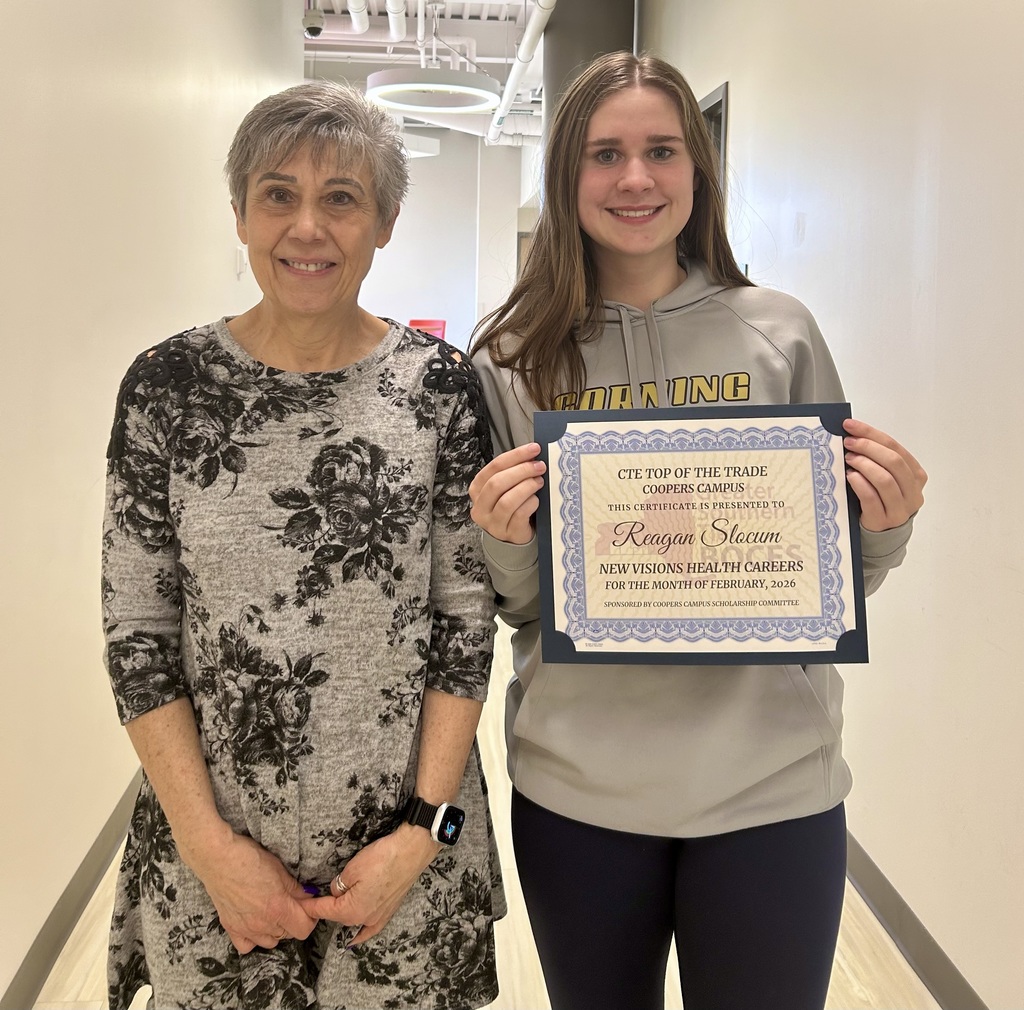 Student holding a certificate next to a staff member 