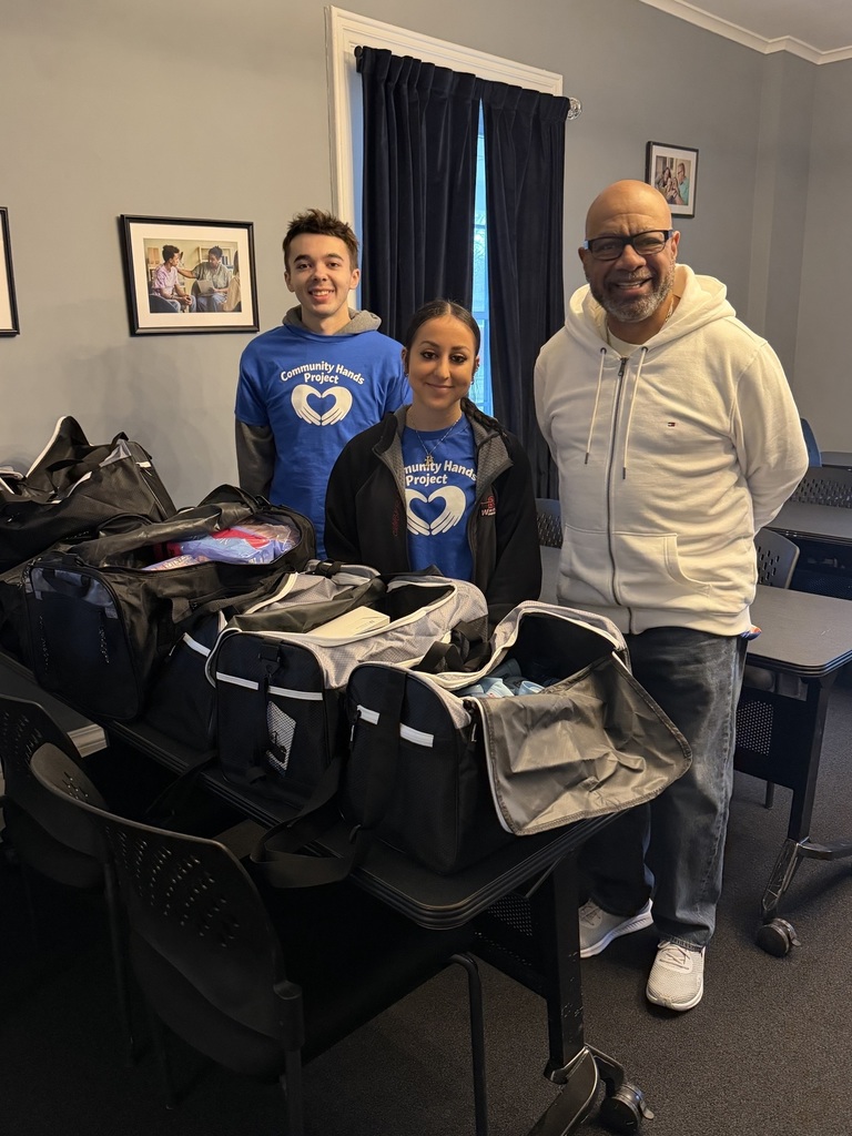 two students giving donations to Glove House