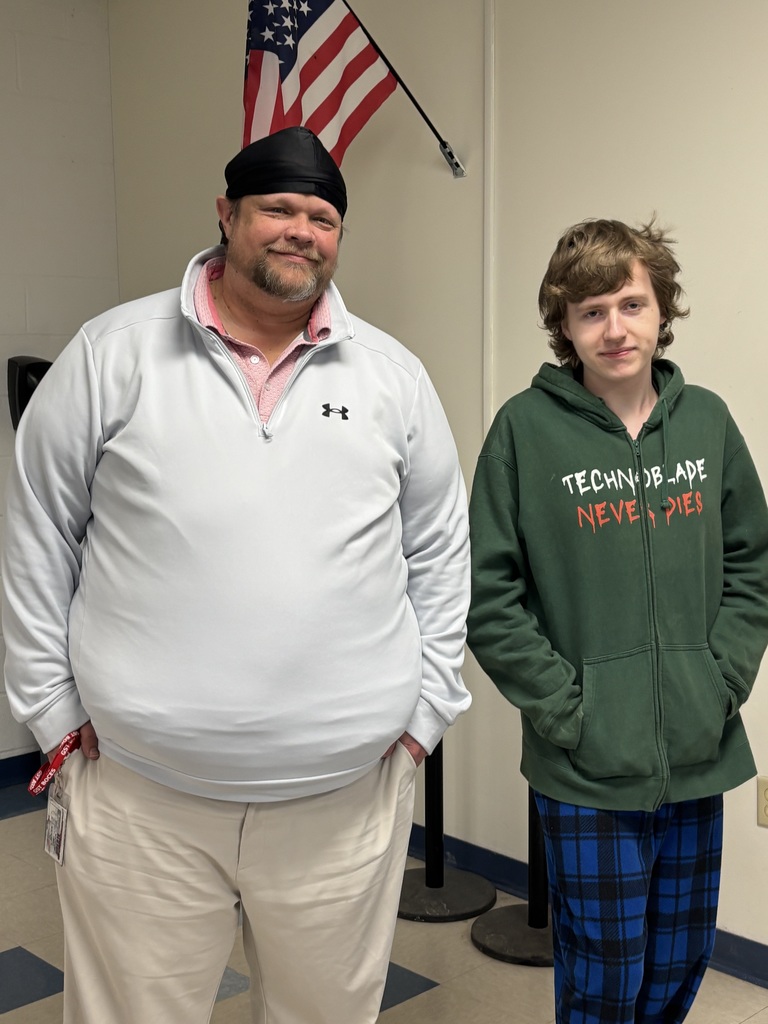 A staff and student smiling at the camera.