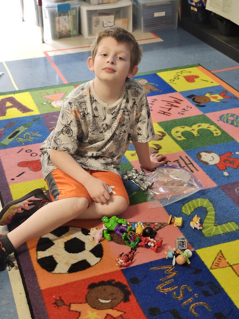 student playing on a carpet with toys