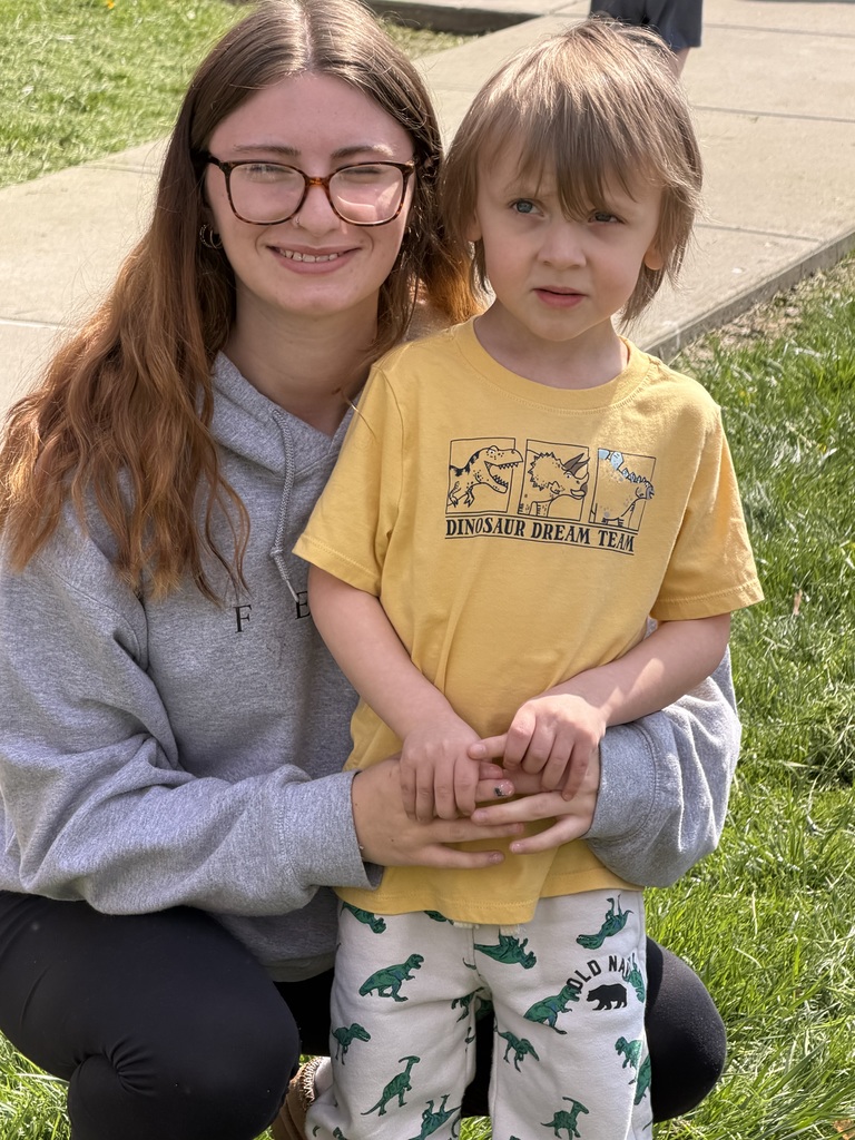 Two students smiling for the camera outside.