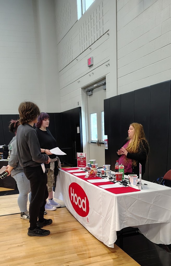 Students and business owner talking at a table
