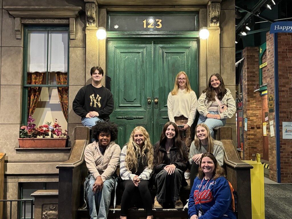 Students sitting at Sesame Street's door.