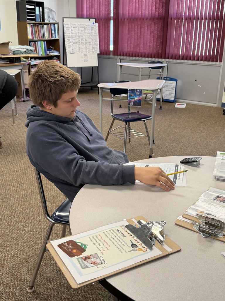 One student sitting at a tabl filling out paperwork.