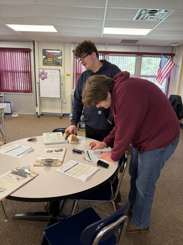 Two students reviewing financial documents at a table.