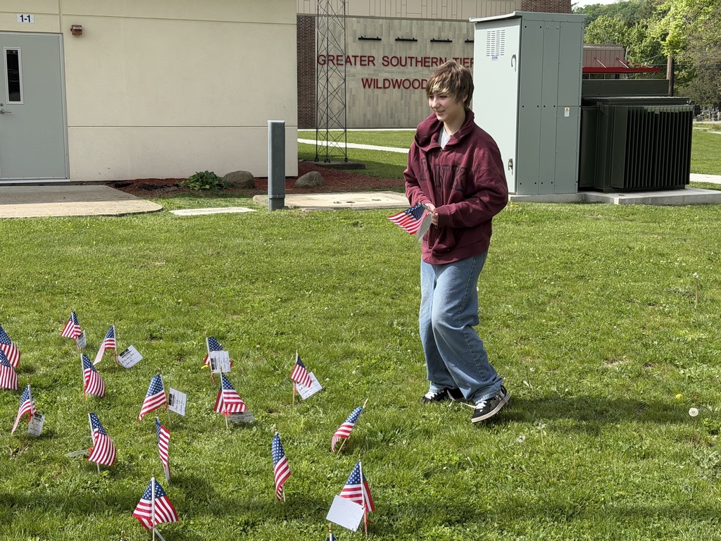 Student putting flags into the garden