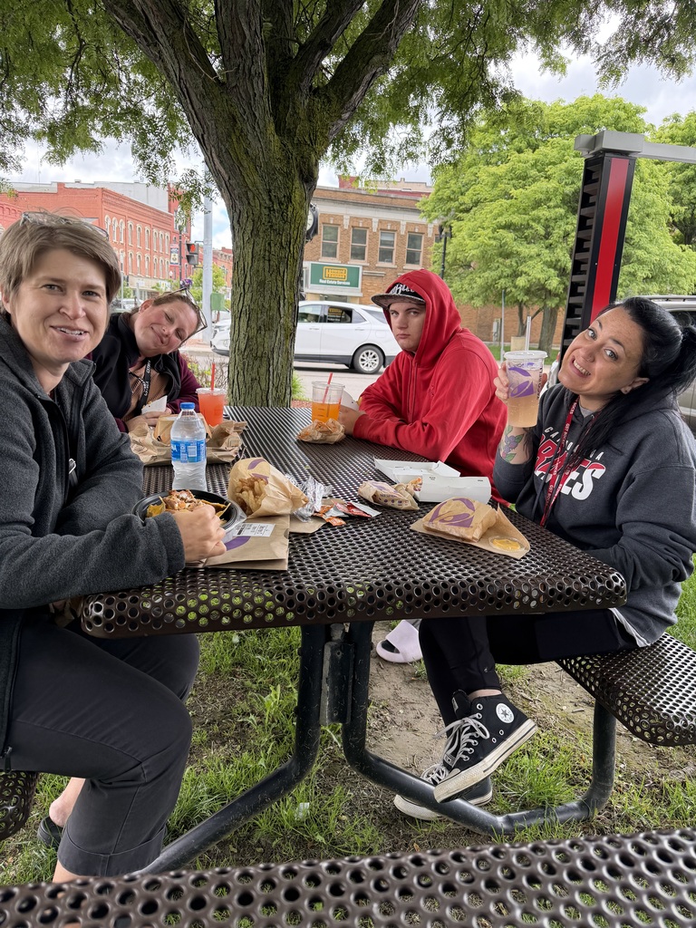 Staff and students at a picnic table smiling