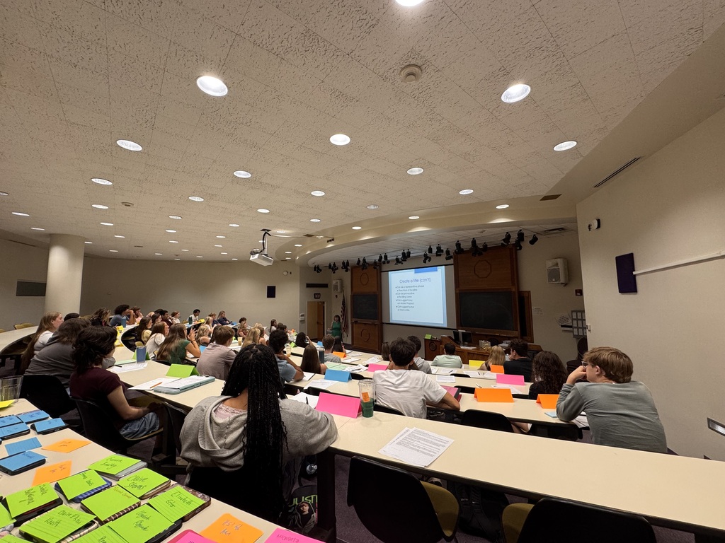 Students sitting at tables looking at the front of the class