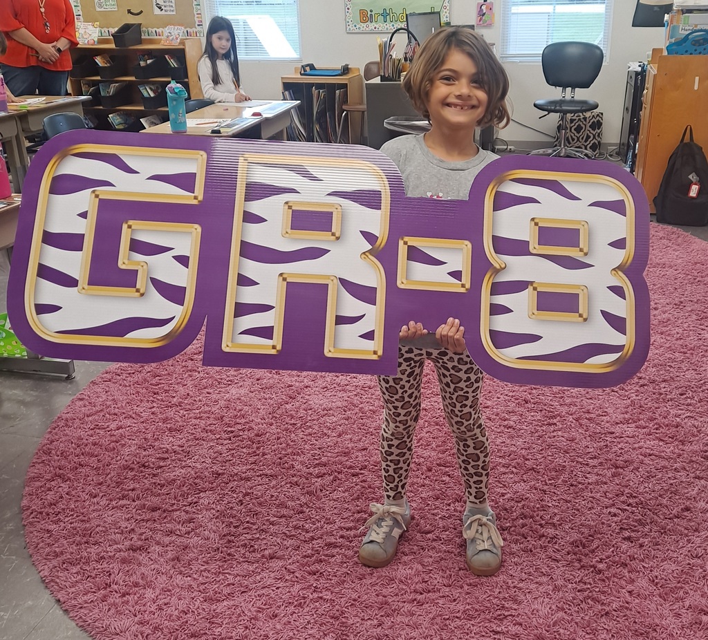 smiling student holding sign