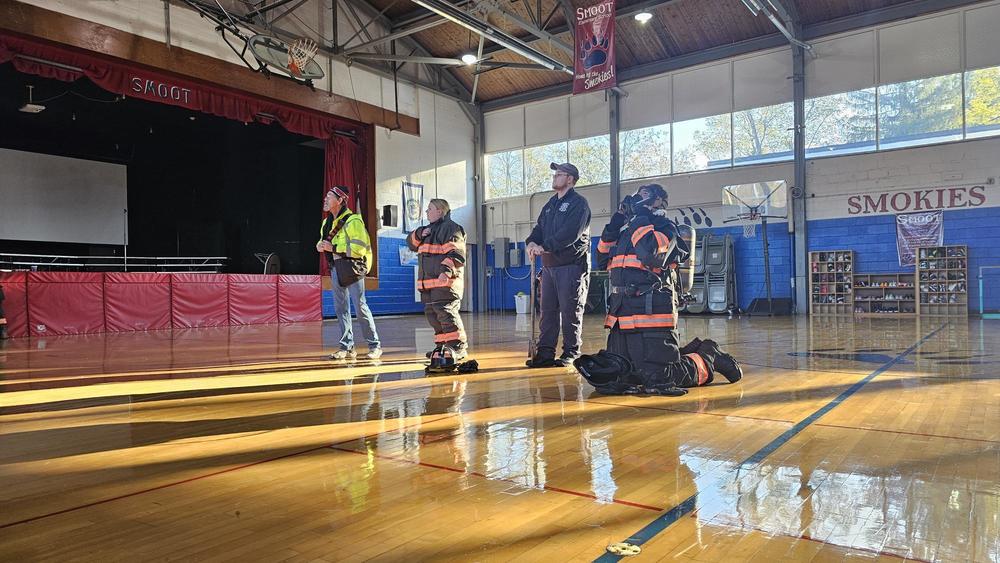 four fire fighters in a gym