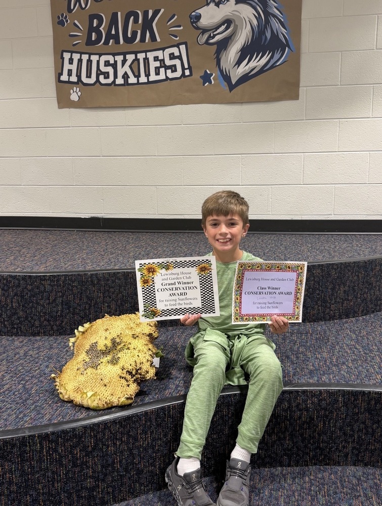 Sunflower Contest Winner with his winner sunflower, Landon Webb