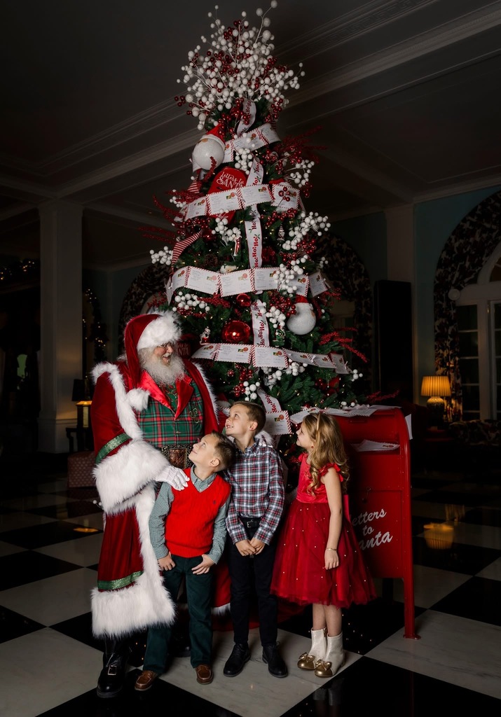 Santa with kids in front of a tree