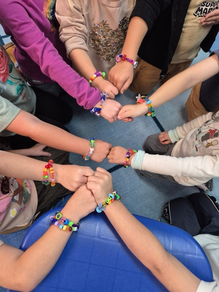 Picture of kids’ wrists with their friendship bracelets they made